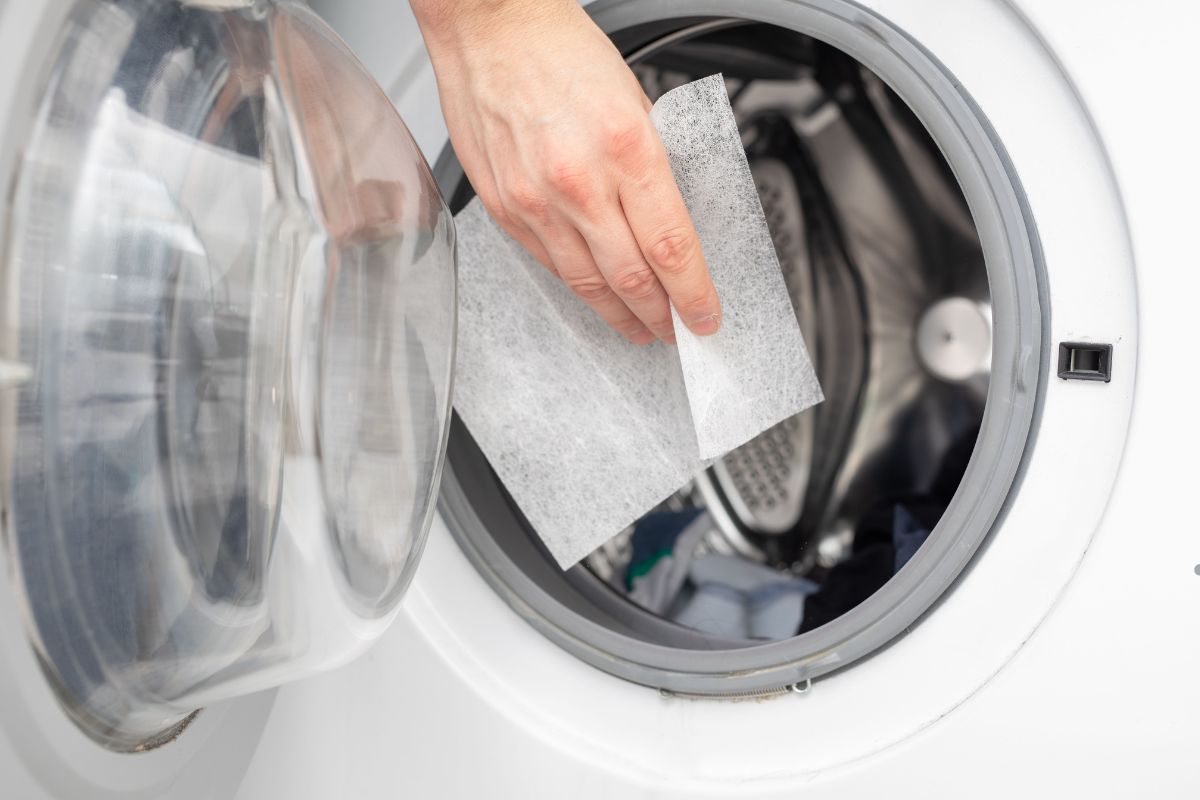 A person inserts a piece of paper into a washing machine labeled "Soak and Scrub."